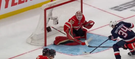 Goalie blocks a shot on goal during an ice hockey game, highlighting key moments in ice hockey betting